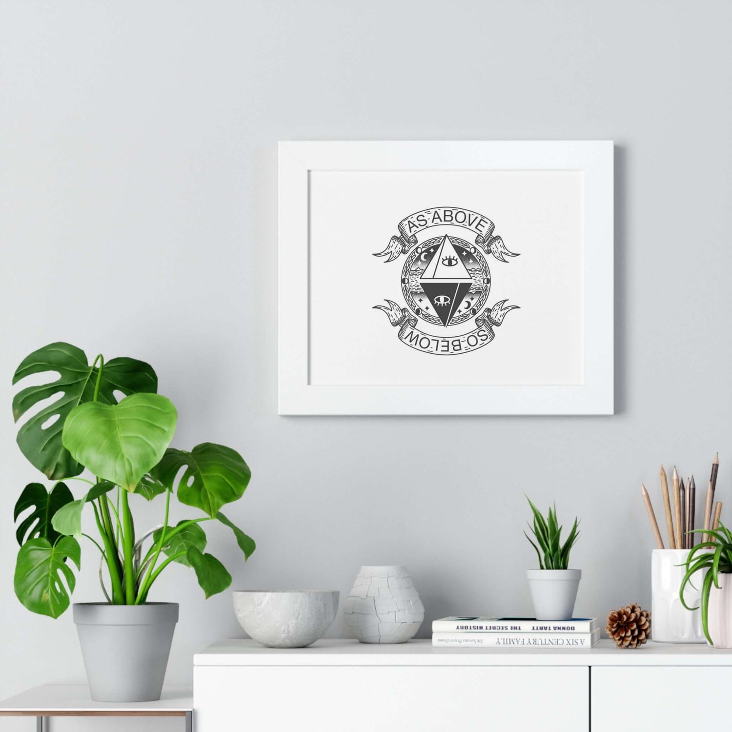 As above so below mystic wall art framed poster in modern living room with plants and decor elements.